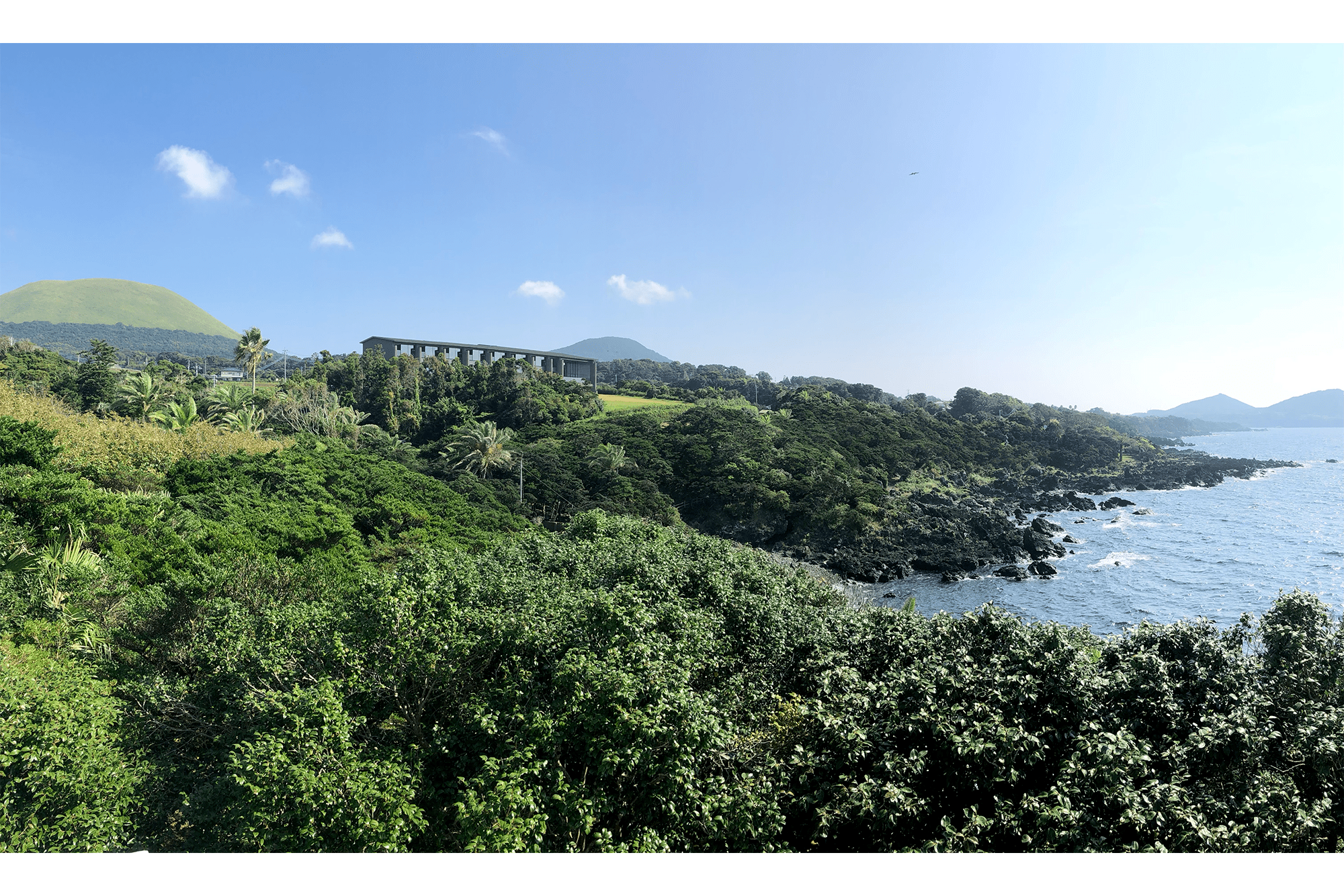 南西側全景：手前の鐙瀬海岸と奥の鬼岳に正対するようにホテルが配置されている